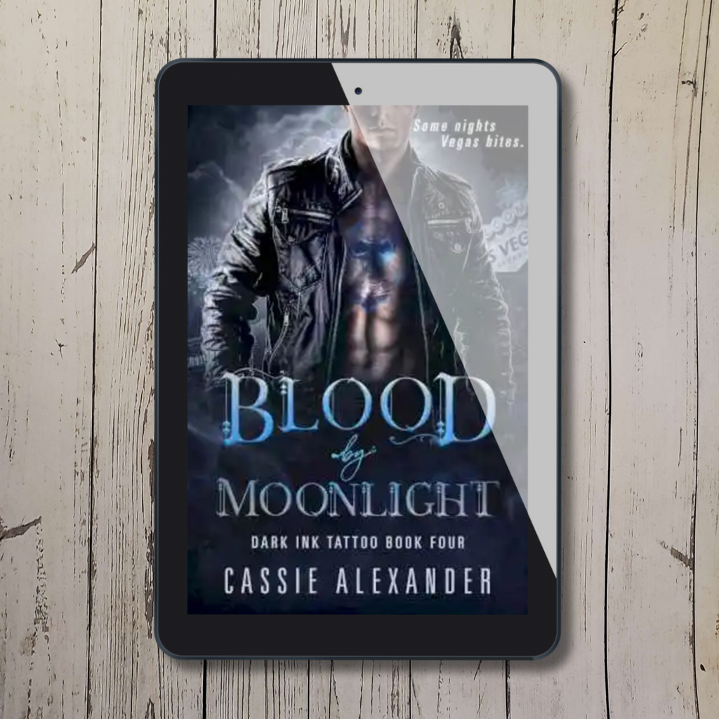 Tablet showing cover of "Blood by Moonlight: Book 4" by Cassie Alexander with a shirtless man in a black leather jacket with a chest tattoo.